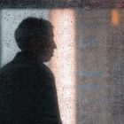silhouette of a person through a dewy window