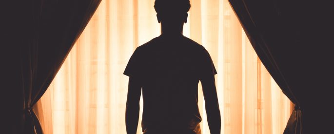 Image of a man's silhouette against a picture window