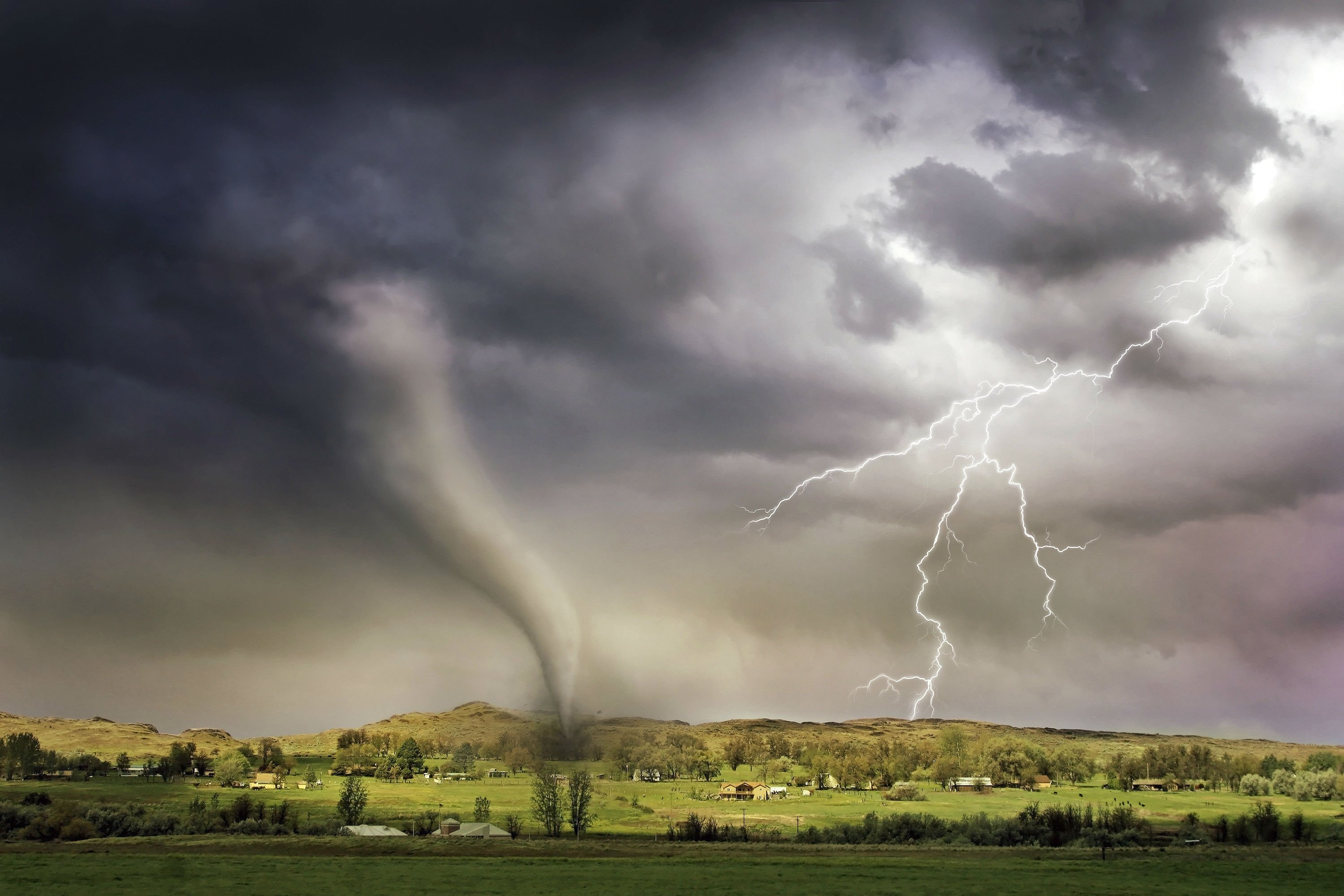 Photo of a tornado and lighting strike in a small village
