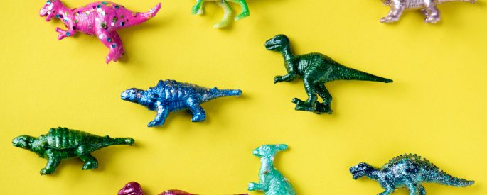 Bright colored dinosaur toys played out against a bright yellow background.