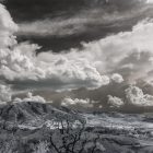 Black and white photograph of storm clouds over a snow-covered mountain range