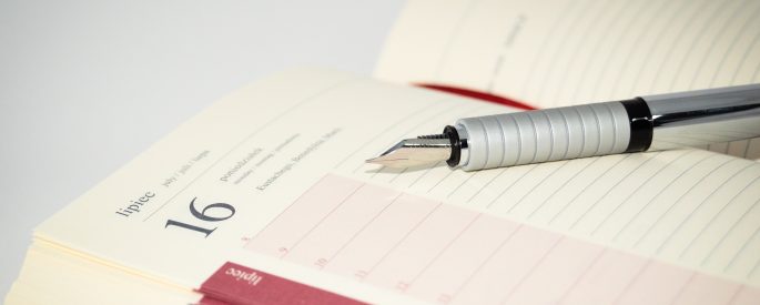 Image of an open agenda book and pen
