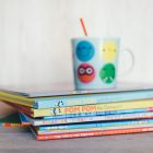 Stacked, colorful children's books sit on a table stacked on top of one another.