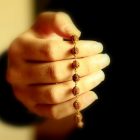 image focused on a woman's hand holding beads
