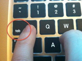 photo of a macbook keyboard with a person's finger pointing to the "tab" key, which is circled in red