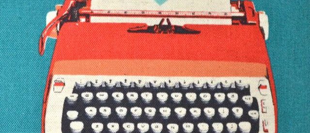 image of a red typewriter on a turquoise background, the paper in the typewriter contains only a turquoise heart