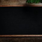 A blank black chalkboard on a wooden table.
