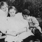 Vintage photo of children huddled around one book reading together