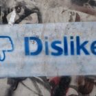 Graffit on a concrete wall with the Facebook "Dislike" thumbs down
