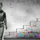 Woman in black and white standing in front of a wall with a graph to "success" on it