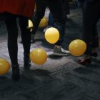 people standing near yellow balloons