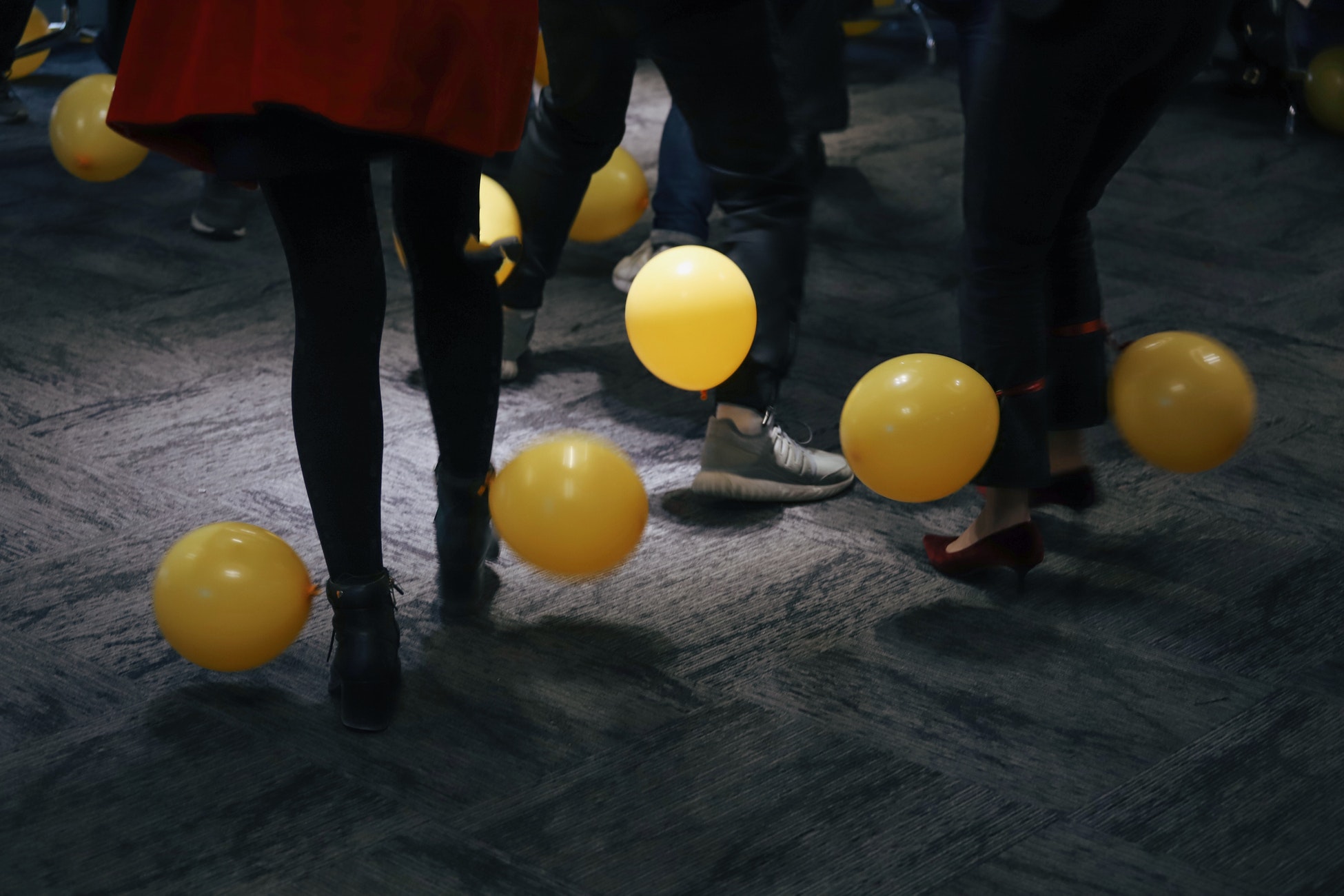 people standing near yellow balloons