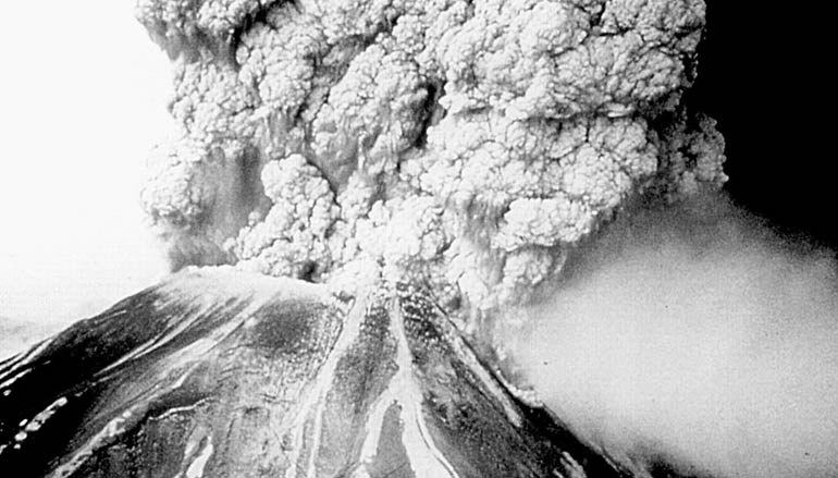 Old black and white picture of a volcano erupting 