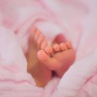 Baby feet on pink blanket.
