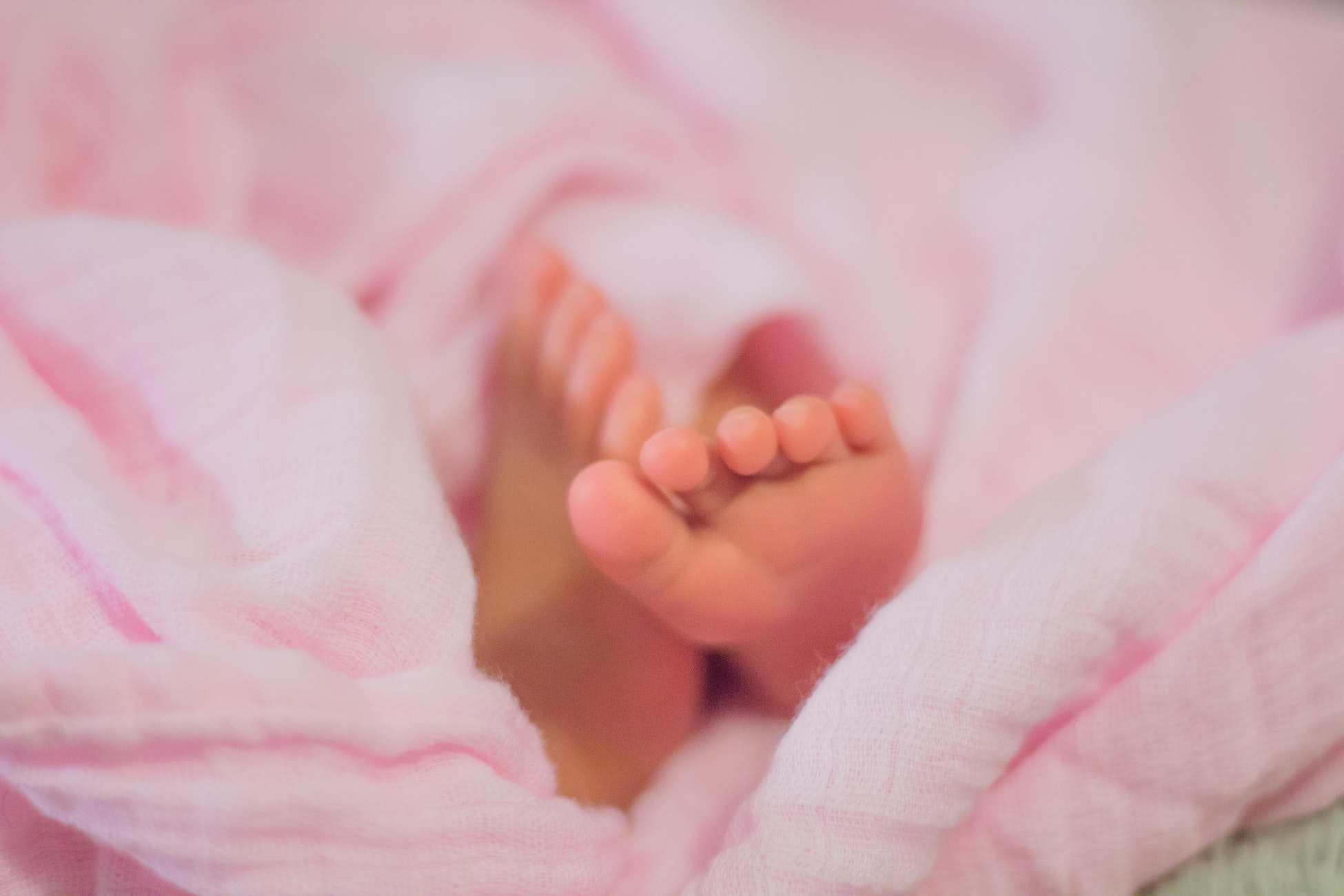 Picture of baby feet on pink blanket.