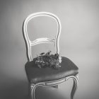 a chair in a dark room with flowers on top of it