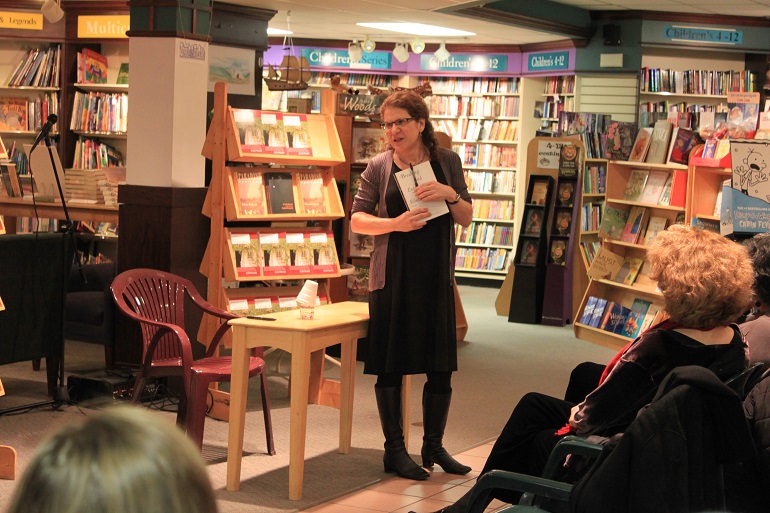Person at a bookstore talking in front of a crowd.