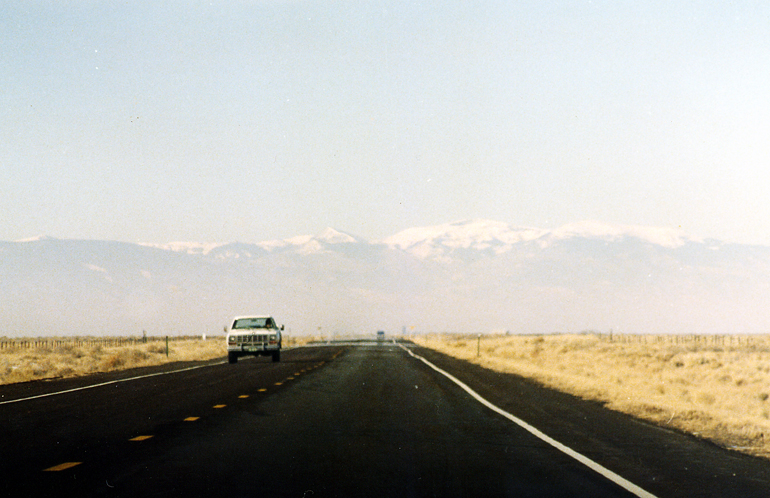 car on the road in front of mountain range