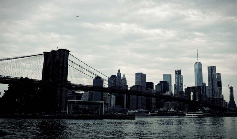 The Brooklyn bridge on a dark, cloudy day.