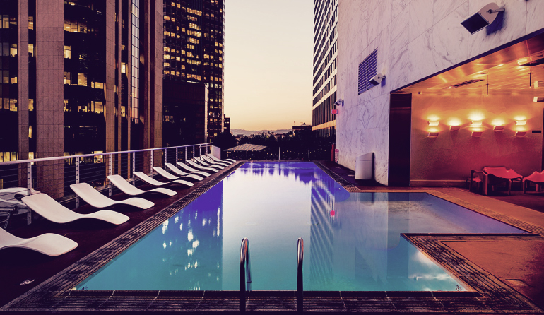 Rooftop pool with skyscrapers in the background.