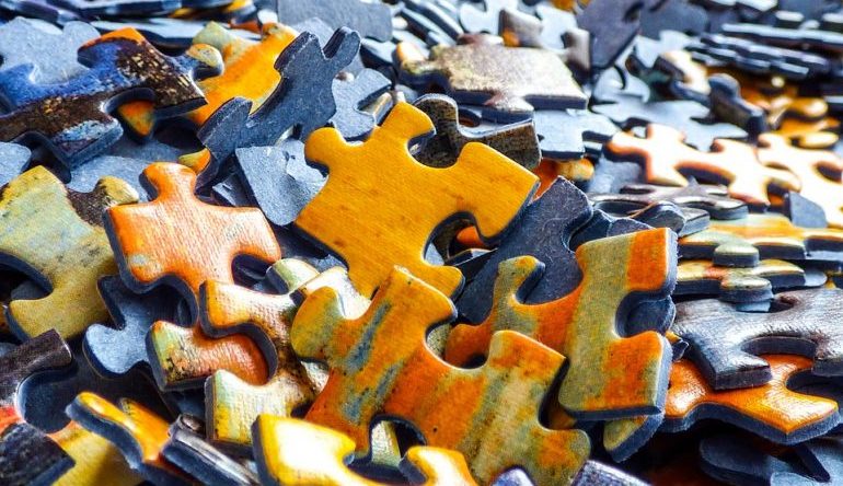 unmatched jigsaw puzzle pieces, in orange, blue, and green