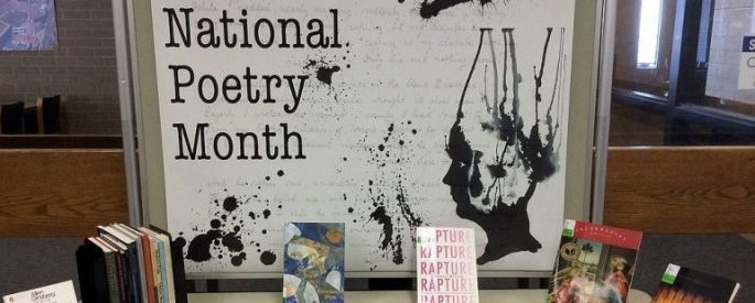 table of books in front of a sign that says "Celebrate National Poetry Month"