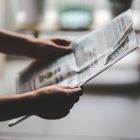 Image of a person holding a newspaper