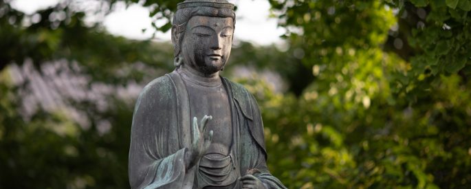 Photograph of an old Buddha statue outdoors