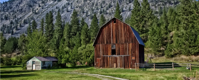 Photograph of a barn and mountains in Montana