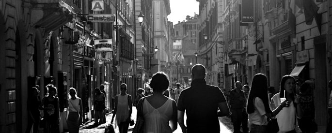 Black and white people walking through a city.