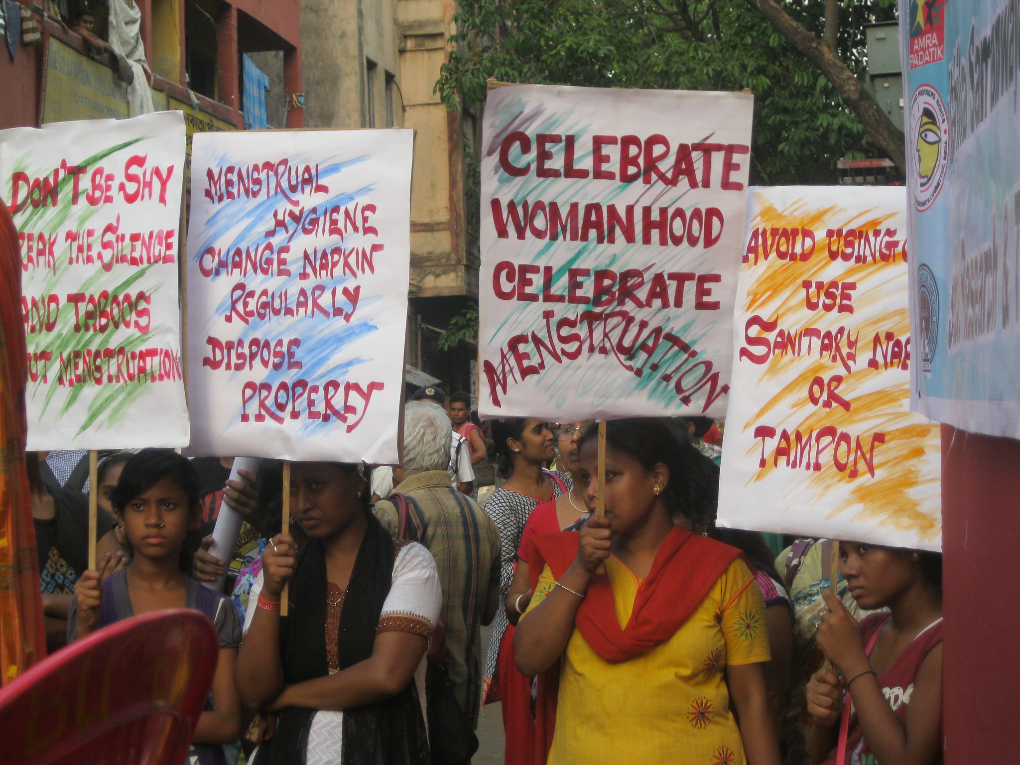 A photograph of women in India holding signs about menstrual hygiene