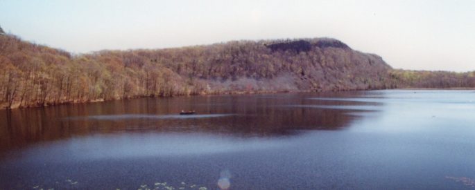 A photograph of a pond and a small mountain