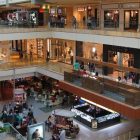 Open look at four levels of shopping mall with tables, stores, and lots of people