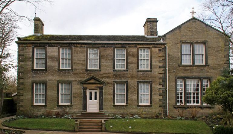 The front of the Bronte Parsonage Museum, a brick house with lots of windows