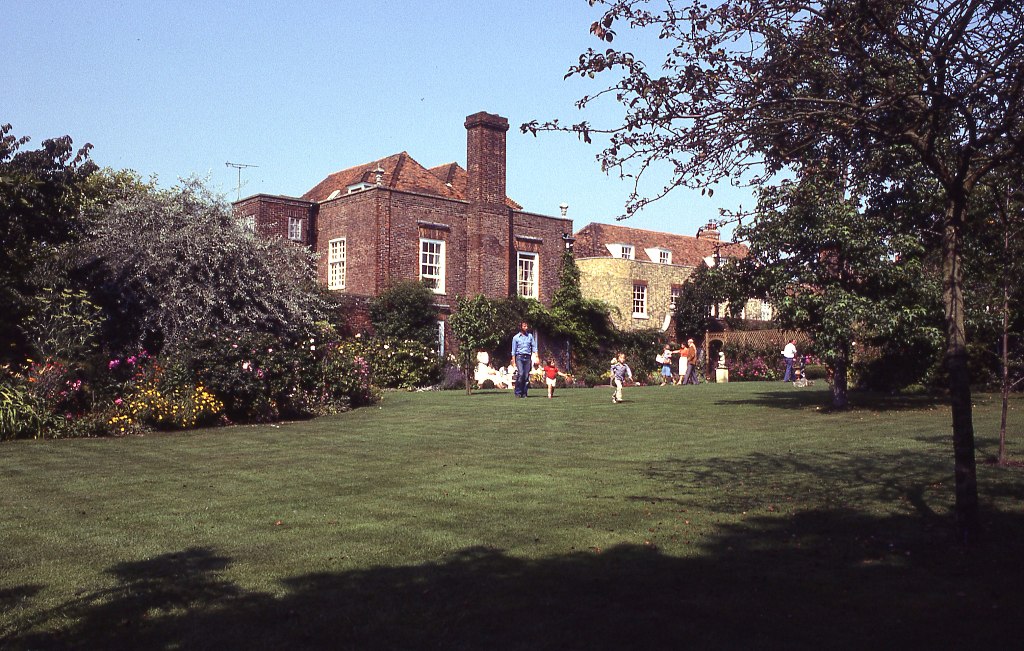 a film photograph of the back of the Lamb House--a small family appears to be playing on the lawn