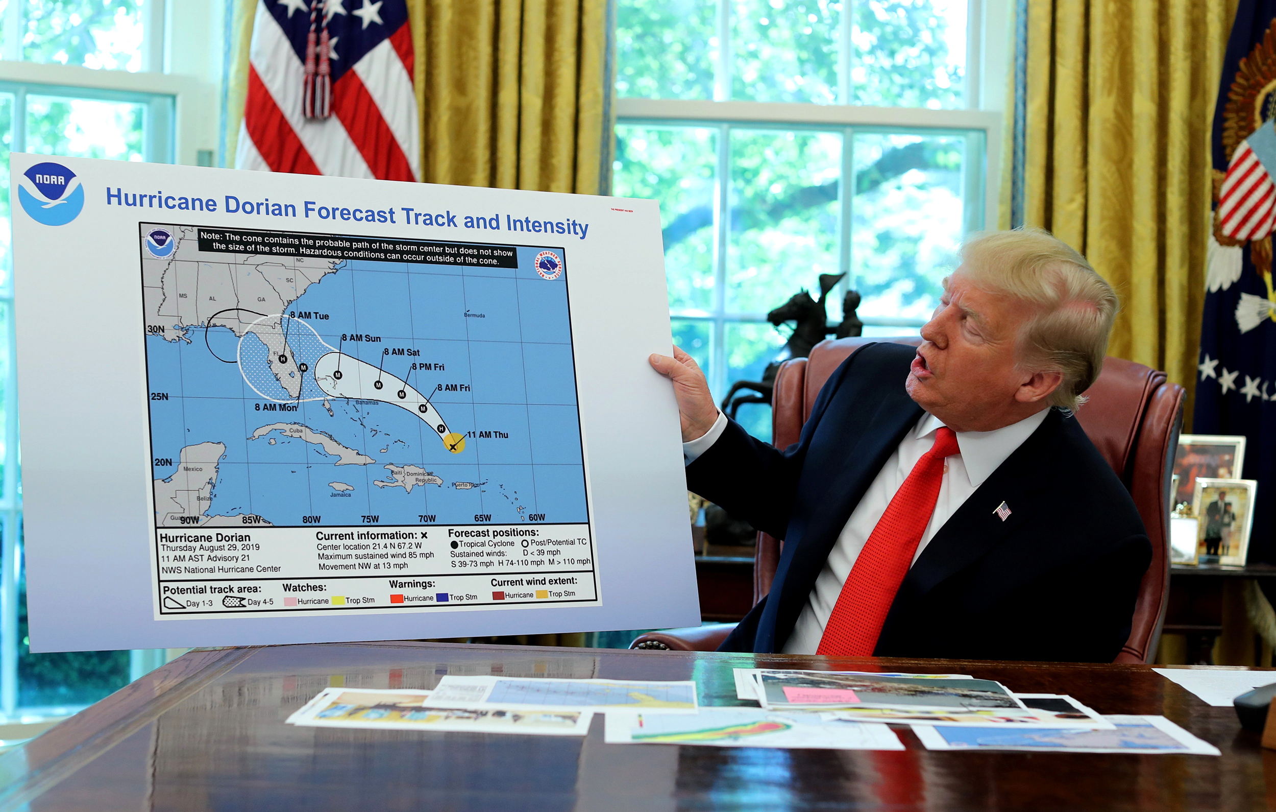 Donald Trump holds up a map of the trajectory of hurricane Dorian