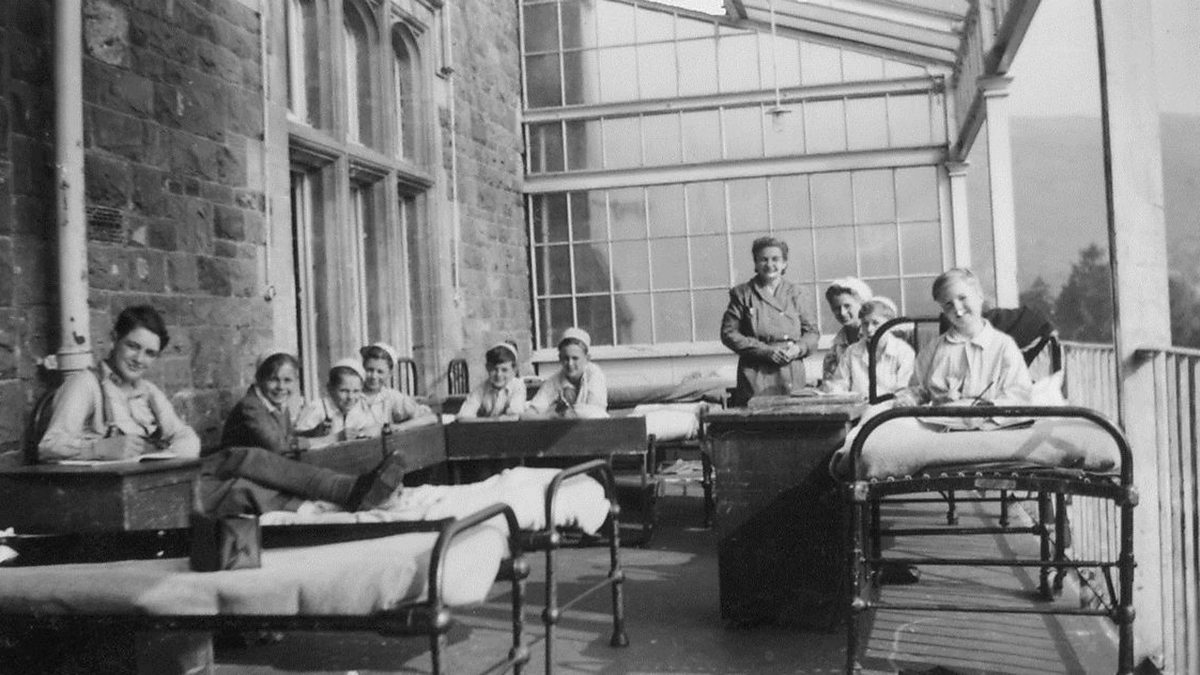 vintage black and white photograph of a hospital interior, where children and nurses are pictured