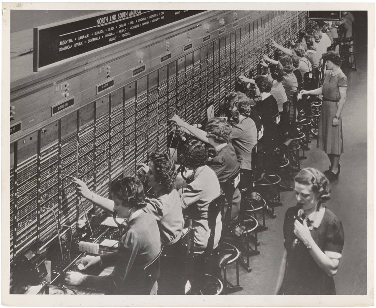 vintage black and white photograph of a line of telephone operators at work 