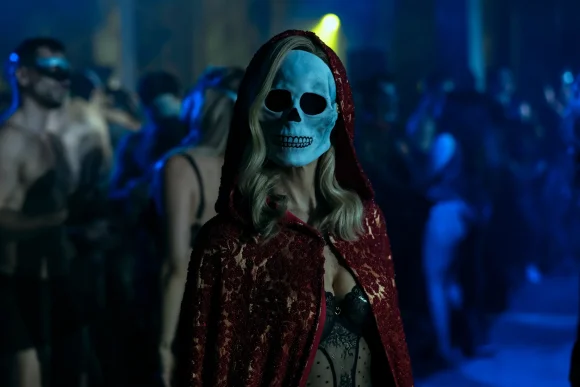 a woman in a red cloak and a skeleton mask